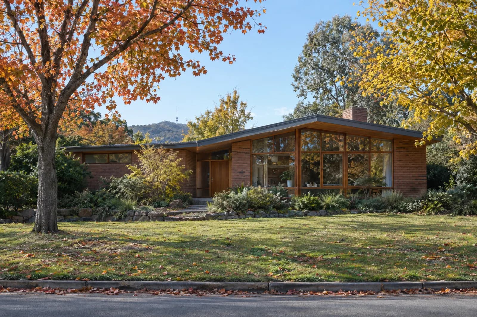 A mid-century brick house among autumn trees in Canberra