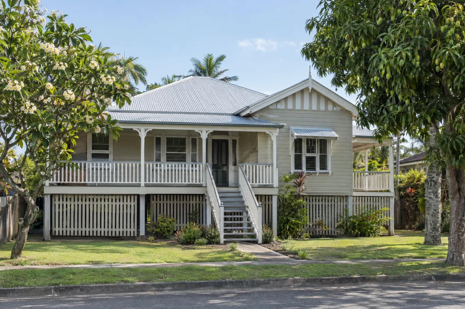 A timber Queenslander on stumps with a wide verandah in a Brisbane street