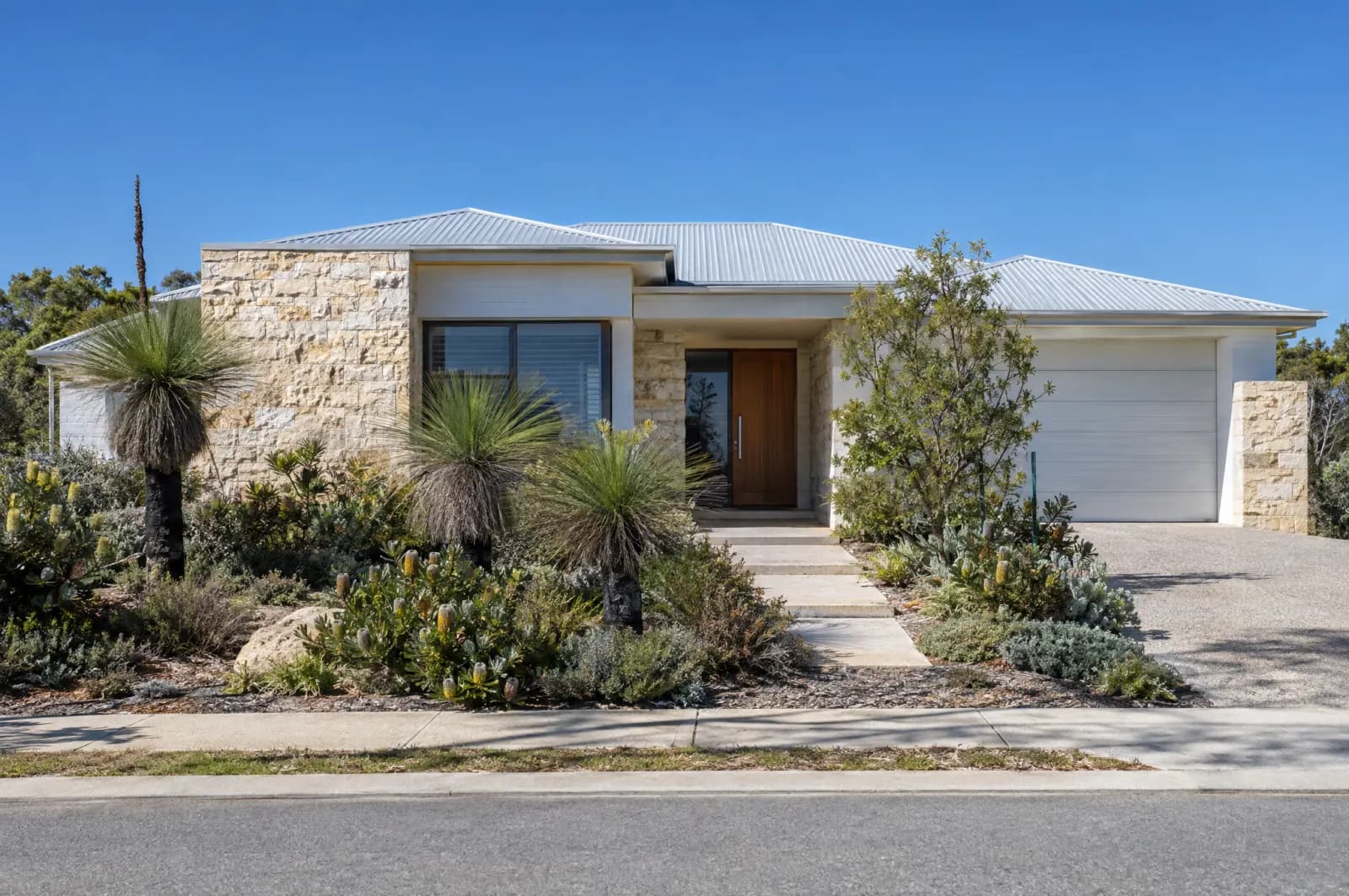 A limestone and white-render home with a native garden in Perth
